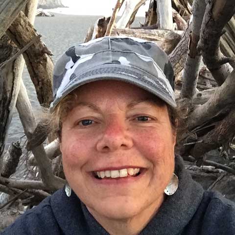 Lisa in a driftwood hut on the beach.